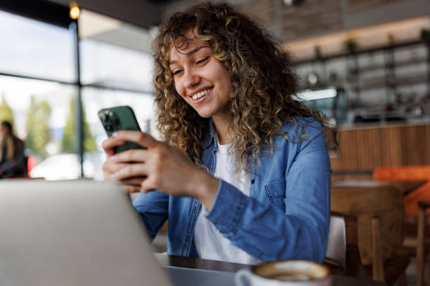 Woman on phone in coffee shop — the everyday AI search user paying the friction tax